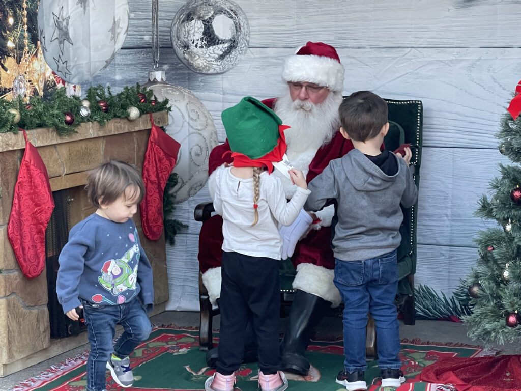 Santa Tom listening to the wishes of young children